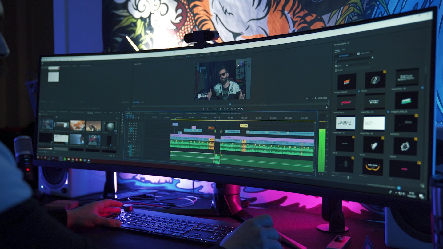 Content creator edits video on curved monitor with RGB lighting.